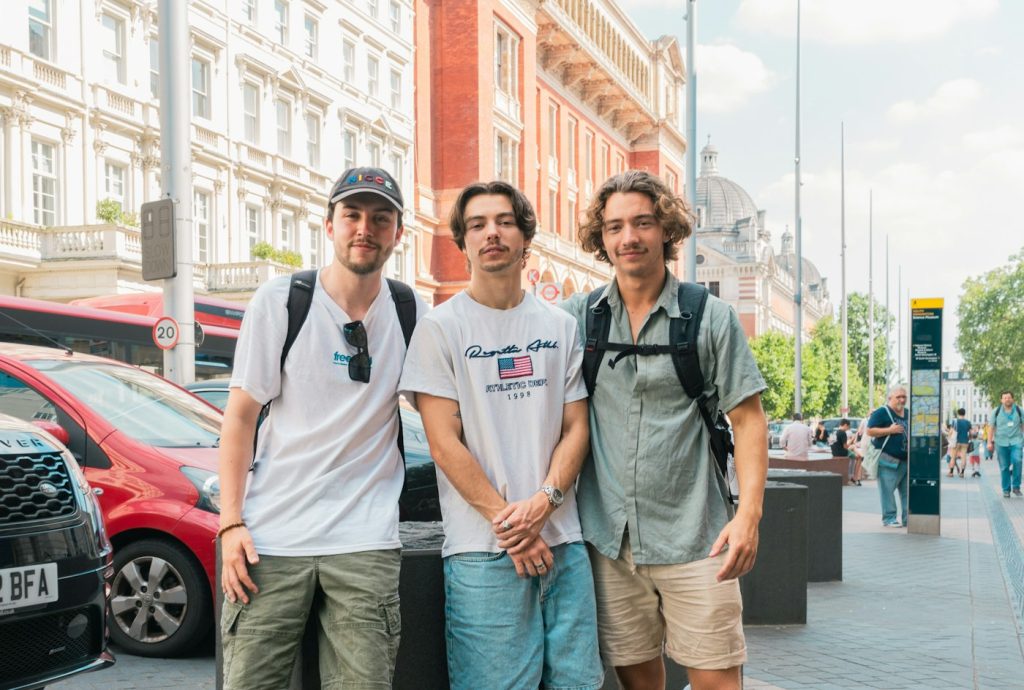 Trois jeunes souriants dans une rue anglaise pendant leur séjour linguistique